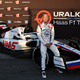 A photo of Nikita Mazepin sat on the wheel of a Haas F1 car.